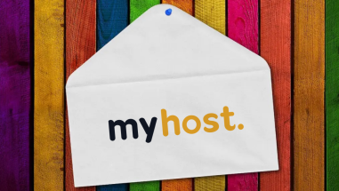 A paper envelope pinned onto a colourful wooden wall, with the MyHost logo printed on the envelope.